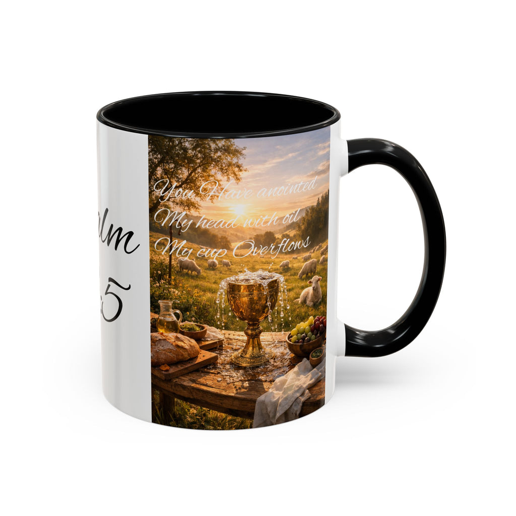 A ceramic coffee mug with a black handle and interior, featuring a printed graphic of a golden chalice at a rustic table with a sunset landscape and sheep, alongside white cursive text and partial black script on a white background.